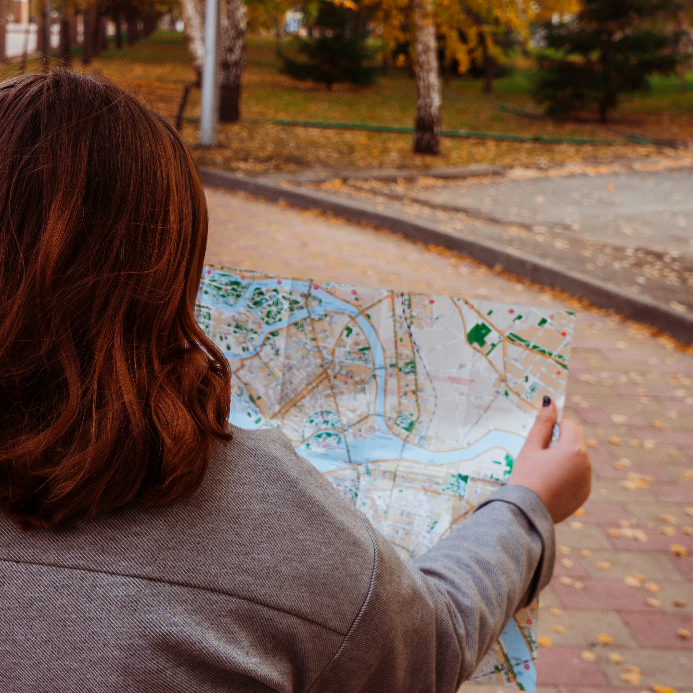 woman looking at a map in a park