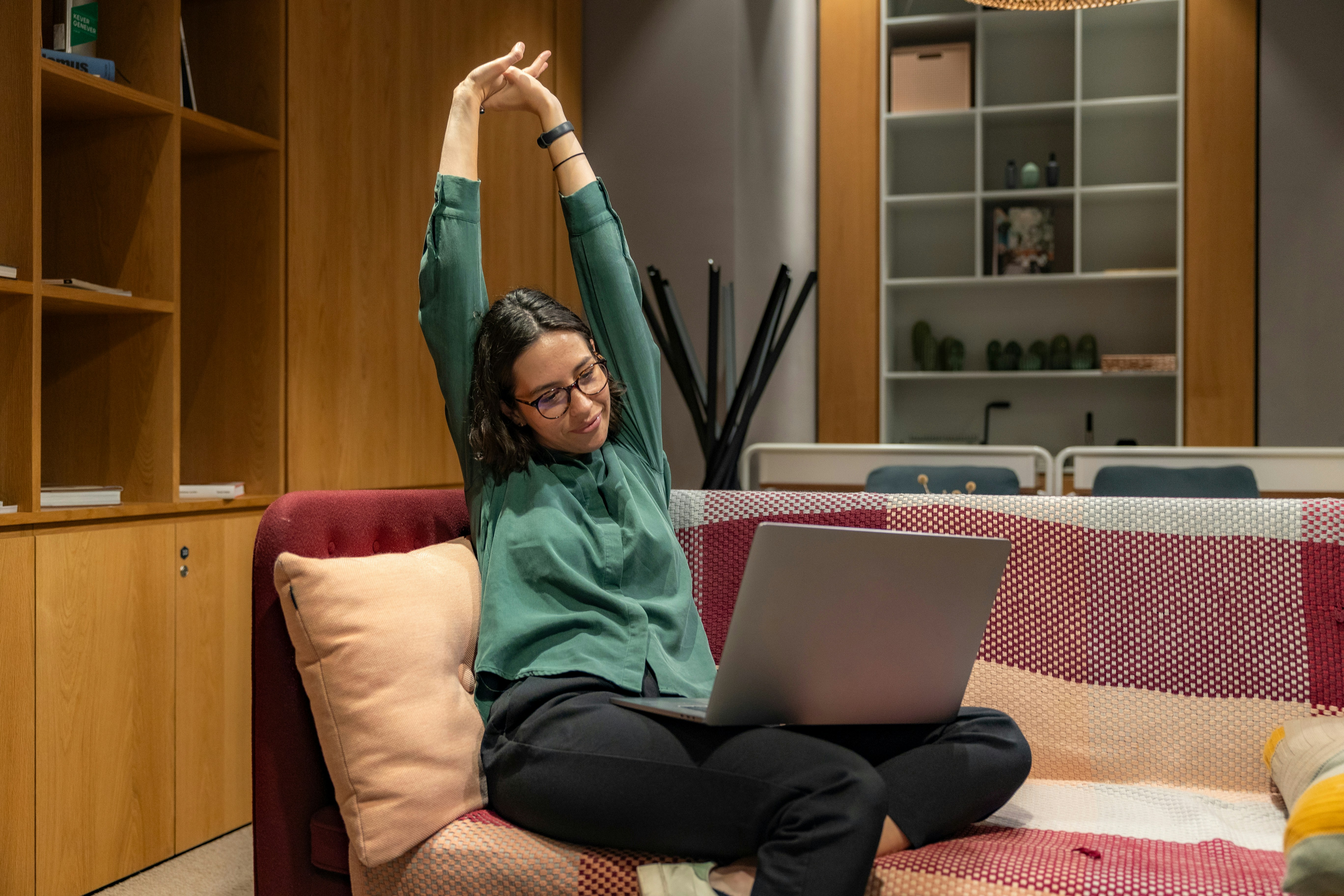 someone stretching while working on a laptop